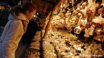 Eine Frau schaut sich einen Stand auf dem Weihnachtsmarkt an (Foto: AFP /Getty Images)