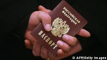 A Russian Navy sailor holds his passport while waiting in line to vote at a polling station in Sevastopol, military base of Russian Black Sea Fleet in Ukraine, on March 2, 2008 the day of the nation's presidential vote. Russians voted on March 2 in a presidential election seen by critics as rigged to hand victory to Vladimir Putin's chosen successor, Dmitry Medvedev. Polls opened on the Pacific coast of the world's biggest country, before rolling 12,000 kms (7,500 miles) west to Moscow, and finally to the Baltic territory of Kaliningrad. AFP PHOTO/ SERGEI SUPINSKY (Photo credit should read SERGEI SUPINSKY/AFP/Getty Images)