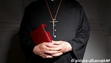 2010-05-28 ILLUSTRATION - Church, a priest in a church, holding a bible. The holy cross on a chain around his neck, his hands folded. This image was produced to illustrate the items about sexual abuse in the church, religious boarding schools and summer camps. ANP XTRA ROOS KOOLE