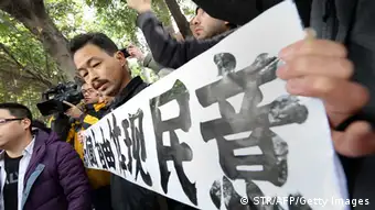 A protester calling for greater media freedom outside the headquarters of Nanfang Media Group in Guangzhou holds up a banner saying freedom of press reflects the public's opinion in Chinese on January 9, 2013. A Chinese weekly newspaper at the centre of rare public protests about government censorship will publish as usual on January 10, a senior reporter said, following reports of a deal to end the row. The row at the popular liberal paper, which had an article urging greater rights protection replaced with one praising the ruling communist party, has seen demonstrators mass outside its headquarters in the southern city of Guangzhou. AFP PHOTO (Photo credit should read STR/AFP/Getty Images)