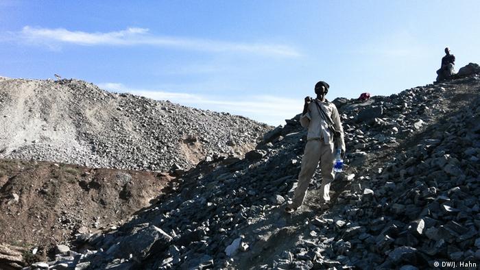 A man stands on mount of debris. He is a so-called intruder, who gathers precious stones from the mine's waste Photo Deutsche Welle, Julia Hahn, November 2012