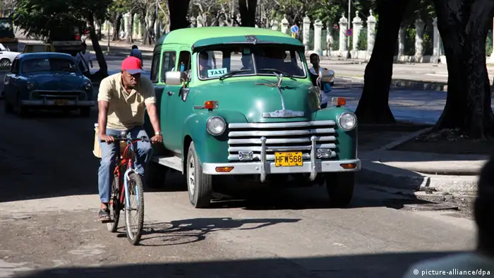 Ein Taxi überholt am 21.01.2012 im kubanischen Havanna einen Radfahrer auf einer Straße. Foto: Friso Gentsch dpa