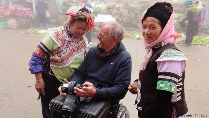 Andreas Pröve zeigt zwei Marktfrauen in Yuenyang, Yunnan, ein Foto in seiner Kamera (Foto: Nagender Chhikara)