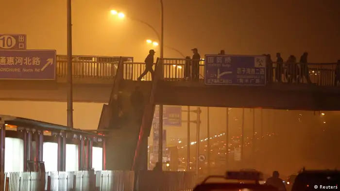 People walk on a pedestrian bridge on a very hazy winter day in Beijing January 12, 2013. Microscopic pollutant particles in the air have killed some 8,600 people prematurely in 2012 and cost $1 billion in economic losses in four Chinese cities, according to a study by Beijing University and Greenpeace. The study of pollutant levels of PM2.5, or particles smaller than 2.5 micrometres in diameter, in Beijing, Shanghai, Guangzhou and Xi'an, called for PM2.5 levels to be cut to World Health Organisation guidelines, which would reduce deaths by over 80 percent, the China Daily newspaper reported. REUTERS/Jason Lee (CHINA - Tags: ENVIRONMENT)