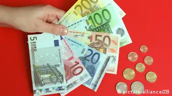 Bergen (Mecklenburg-Vorpommern): Das symbolische Foto zeigt eine Hand mit sechs der sieben neuen Euro-Banknoten und die acht Euro-Münzen in den Nennwerten 1 Cent bis 2 Euro, aufgenommen am 28.11.2001 in einer Sparkasse in Bergen. Nicht mit abgebildet ist die 500-Euro-Banknote. Die ab dem 01.01.2002 gültigen Banknoten sind in den Hauptfarben Grau (5er), Rot (10er), Blau (20er), Orange (50er), Grün (100er), Gelb-Braun (200er) und Lila (500er) gehalten. Ab dem 01.01.2002 ist der Euro das offizielle Zahlungsmittel in den Ländern Belgien, Deutschland, Finnland, Frankreich, Griechenland, Irland, Italien, Luxemburg, Niederlanden, Österreich, Portugal und Spanien. (STR415-031201)