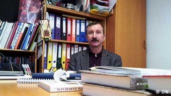 Kuzma Kozak hinter seinem Schreibtisch in der Geschichtswerkstatt Minsk (Foto: DW/Olga Kapustina)