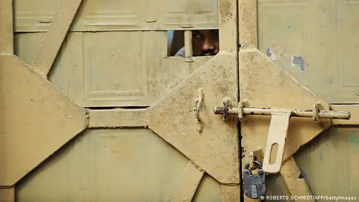 A man peeks through an opening of a door to a prison ward during a concert at the Tihar jail in New Delhi on April 26, 2012. The event was an unusual break from the daily routine at Tihar jail, a vast complex in the west of the Indian capital where 12,000 inmates ranging from trial suspects to convicted murderers are incarcerated. According to the International Center for Prison Studies, India houses some 330,000 inmates in its prisons, making it the fifth largest inmate population in the world. AFP PHOTO/ROBERTO SCHMIDT (Photo credit should read ROBERTO SCHMIDT/AFP/GettyImages)