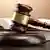 A gavel sits on a table along with legal books