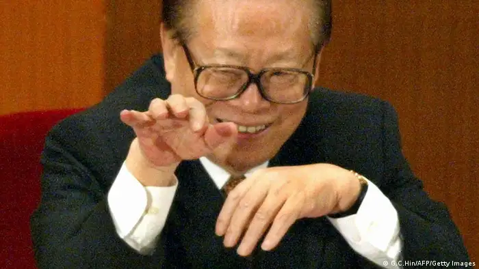 BEIJING, CHINA: Former Chinese president Jiang Zemin waves to a delegate during the closing session of the National People's Congress (NPC) in the Great Hall of the People in Beijing, 14 March 2004. China ended its annual session of parliament 14 March, with the rubber-stamp congress keeping its record of never opposing a government proposal or document intact for 50 straight years. AFP PHOTO/GOH CHAI HIN (Photo credit should read GOH CHAI HIN/AFP/Getty Images)