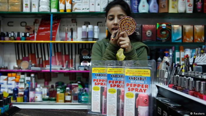 A salesgirl applies lipstick inside a shop (Photo: REUTERS/Mansi Thapliyal)