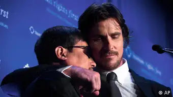 Actor Christian Bale hugs Chinese activist Chen Guangcheng at the podium during the Human Rights First Dinner at Pier 60 at Chelsea Piers, Wednesday, Oct. 24, 2012, in New York. Guangcheng, a blind lawyer and activist made headlines earlier this year after the Chinese government allowed him to travel to the U.S. following his escape from house arrest and request for American protection. (Foto:John Minchillo/AP/dapd)