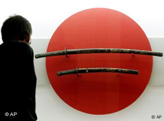 Ein Besucher betrachtet Schwerter eines Samurai in einer Ausstellung (Foto: AP)