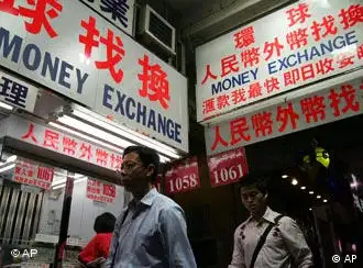 People walk past a money exchange for yuan in Hong Kong Thursday, July 21, 2005. China said it will no longer peg its currency, the yuan, to the U.S. dollar but instead let it float in a tight band against a basket of foreign currencies. The yuan has been strengthened, effective immediately, to a rate of 8.11 to the U.S. dollar - compared to the 8.28 it has been set at for more than a decade - and the new trading regime will begin Friday, the government said in an announcement on state television. (AP Photo/Vincent Yu)