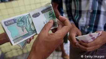 Burma erhält Schuldenerlass über sechs Milliarden DollarYANGON, MYANMAR - APRIL 5: Money changers hold the Burmese kyat as they change money for tourists April 5, 2012 in Yangon, Myanmar. The state-run New Light of Myanmar newspaper recently announced the managed float of the Burmese kyat, abandoning the peg of 8.5 kyat to the dollar. Markets determined the rate Tuesday at 818 to the dollar. U.S Secretary of state Hilary Clinton just announced the United States is ready to relax sanctions on Burma to allowing the country to move forward with democratic transition. Washington would ease a ban on US companies investing in or offering financial services to the country. (Photo by Paula Bronstein/Getty Images)