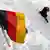 Человек проходит мимо государственного флага Германии