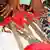 Das undatierte Bild zeigt eine Frau in Sierra Leone, die Werkzeuge zur Genitalverstümmelung afrikanischer Mädchen zeigt. Die Beschneidung hat in vielen Ländern Afrikas eine lange Tradition, die Mädchen auf ihre Rolle als Frau und Mutter vorbereiten soll. Frauenrechtlerin Rugiatu Turay kämpft in ihrer Heimat Sierra Leone gegen das Ritual der Genitalverstümmelung. 2003 gründete die 32-Jährige die Frauenrechtsorganisation Amazonian Initiative Movement (AIM), die gegen die Beschneidung kämpft. Foto: Plan International dpa/lno (zu dpa/lno-Korr. "Schweigen brechen: Turays Kampf gegen Genitalverstümmelung" vom 14.07.2009) +++(c) dpa - Report+++