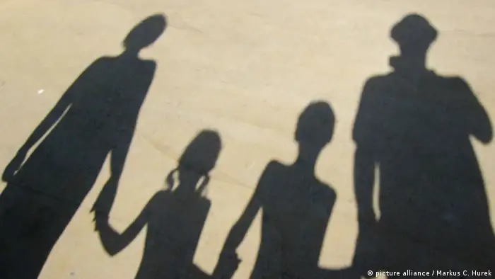 Der Schatten einer Familie, die sich an der Hand hält