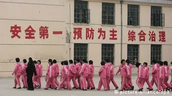 --FILE--A Chinese police officer escorts inmates at a female labor camp in Jurong city, east Chinas Jiangsu province, 6 March 2008. Meng Jianzhu, who became secretary of the Political and Legal Affairs Committee in November, said at a national law and order work conference that the re-education through labour, or laojiao, system would be halted after the move was rubber-stamped by the National Peoples Congress in March. The remarks were first reported by the bureau chief of the Legal Daily, the Justice Ministrys official mouthpiece, and were picked up by state media outlets. An official who attended the event confirmed Mengs comments. But state media sent mixed signals about the policy. A Xinhua report on the conference said only that authorities had pledged to reform the system, and some analysts noted that Meng spoke of halting rather than abolishing the laojiao system. pixel