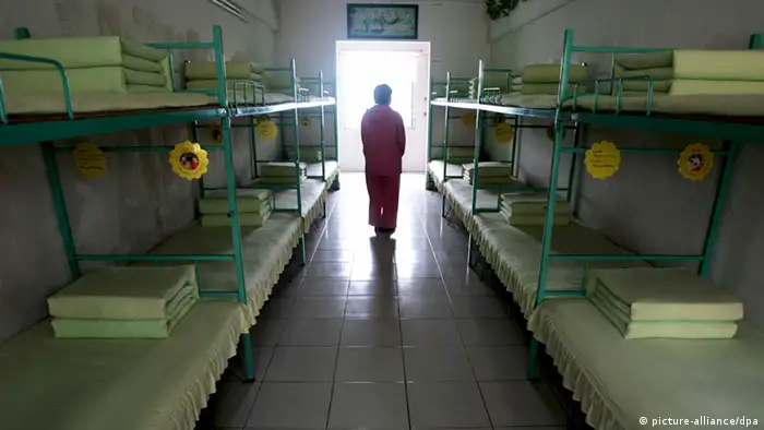 --FILE--A Chinese inmate walks past beds in a room at a female labor camp in Jurong city, east Chinas Jiangsu province, 6 March 2008. Meng Jianzhu, who became secretary of the Political and Legal Affairs Committee in November, said at a national law and order work conference that the re-education through labour, or laojiao, system would be halted after the move was rubber-stamped by the National Peoples Congress in March. The remarks were first reported by the bureau chief of the Legal Daily, the Justice Ministrys official mouthpiece, and were picked up by state media outlets. An official who attended the event confirmed Mengs comments. But state media sent mixed signals about the policy. A Xinhua report on the conference said only that authorities had pledged to reform the system, and some analysts noted that Meng spoke of halting rather than abolishing the laojiao system. pixel