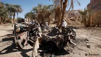 People gather near the wreckage of a car destroyed by a U.S. drone air strike that targeted suspected al Qaeda militants in August 2012, in the al-Qatn district of the southeastern Yemeni province of Hadhramout February 5, 2013. U.S. drones have launched almost daily raids on suspected al Qaeda militants in Yemen during the past two weeks, and air strikes have aggravated discontent among Yemenis, who say the strikes pose a threat to civilians. REUTERS/Khaled Abdullah (YEMEN - Tags: POLITICS CIVIL UNREST MILITARY)