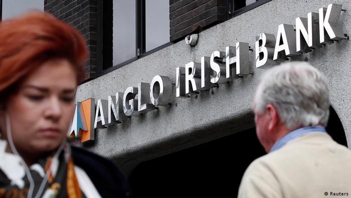 Pedestrians are seen walking past a branch of the Anglo Irish Bank in Dublin in this September 30, 2010 file photograph. The European Central Bank moved towards agreeing a deal on February 7, 2013 to ease Ireland's debt burden after Dublin rushed through emergency legislation to liquidate the failed Anglo Irish Bank. REUTERS/Cathal McNaughton/Files (IRELAND - Tags: BUSINESS POLITICS)
