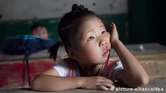 ©ChinaFotoPress/MAXPPP - MACHENG, CHINA - SEPTEMBER 01: (CHINA OUT) 5-year-old Lu Siling looks on at Nangang village primary school during the first day of school on September 1, 2012 in Macheng, Hubei Province of China. There are 5,000 pupils in Shunhe town of Macheng city. About 2,000 new desks have been sent to the hope primary school and the central primary school in Shunhe town. So there are more than 3,000 children left, and they have to go to school with desks and chairs on their own, like their parents\' generation. Even some children use their parents\' old desks. Premier Wen Jiabao\'s announcement at the National People\'s Congress on March 5, 2012 that fiscal expenditure on education will reach 4 percent of GDP this year, about 2 trillion yuan ($317 billion). (Photo by ChinaFotoPress)***_***431358154