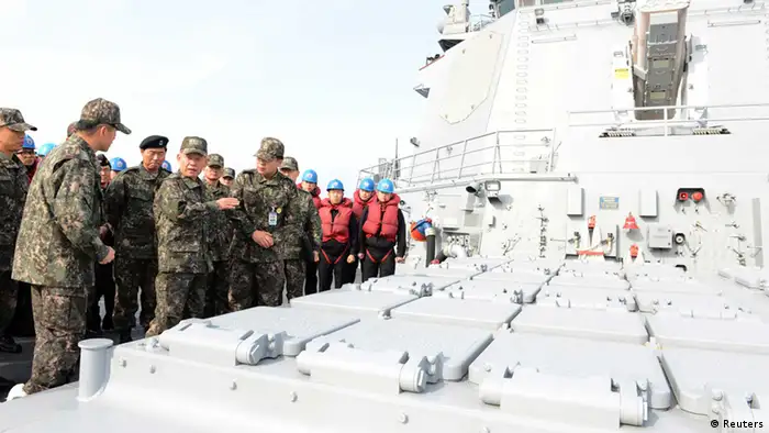 South Korean Naval Chief of Staff Choi Yun-hee (2nd L, front) talks with officers in front of launch pad equipped with cruise missiles on South Korean Navy's Aegis destroyer Sejong on the sea off Busan, southeast of Seoul February 14, 2013. South Korea unveiled a cruise missile on Thursday that it said can hit the office of North Korea's leaders, trying to address concerns that it is technologically behind its unpredictable rival which this week conducted its third nuclear test. REUTERS/South Korean Navy/Handout (SOUTH KOREA - Tags: MILITARY POLITICS) ATTENTION EDITORS - THIS IMAGE WAS PROVIDED BY A THIRD PARTY. FOR EDITORIAL USE ONLY. NOT FOR SALE FOR MARKETING OR ADVERTISING CAMPAIGNS. THIS PICTURE IS DISTRIBUTED EXACTLY AS RECEIVED BY REUTERS, AS A SERVICE TO CLIENTS. SOUTH KOREA OUT. NO COMMERCIAL OR EDITORIAL SALES IN SOUTH KOREA