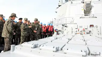 South Korean Naval Chief of Staff Choi Yun-hee (2nd L, front) talks with officers in front of launch pad equipped with cruise missiles on South Korean Navy's Aegis destroyer Sejong on the sea off Busan, southeast of Seoul February 14, 2013. South Korea unveiled a cruise missile on Thursday that it said can hit the office of North Korea's leaders, trying to address concerns that it is technologically behind its unpredictable rival which this week conducted its third nuclear test. REUTERS/South Korean Navy/Handout (SOUTH KOREA - Tags: MILITARY POLITICS) ATTENTION EDITORS - THIS IMAGE WAS PROVIDED BY A THIRD PARTY. FOR EDITORIAL USE ONLY. NOT FOR SALE FOR MARKETING OR ADVERTISING CAMPAIGNS. THIS PICTURE IS DISTRIBUTED EXACTLY AS RECEIVED BY REUTERS, AS A SERVICE TO CLIENTS. SOUTH KOREA OUT. NO COMMERCIAL OR EDITORIAL SALES IN SOUTH KOREA