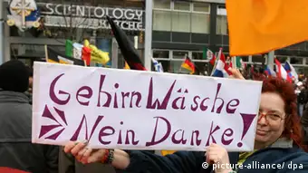 Scientology Zentrale in Berlin Caption: Eine Demonstrantin protestiert mit einem Schild, das den Slogan Gehirnwäsche - Nein Danke ! trägt vor der neuen Hauptstadtrepräsentanz der Scientology-Gemeinschaft am Sonnabend (13.01.2007) in Berlin. Nach Polizeiangaben reisten rund 1500 Scientology-Unterstützer aus Deutschland und Europa an. Einige Anwohner protestierten mit Schildern wie «Gehirnwäsche. Nein Danke.». Die umstrittene Organisation wird von Kritikern als Sekte und skrupelloses Wirtschaftsunternehmen bezeichnet. Scientology bezeichnet sich selbst als Religionsgemeinschaft. Experten rätseln, ob das Haus in Berlin-Charlottenburg die neue Deutschlandzentrale der Organisation wird. Foto: Tim Brakemeier dpa/lbn +++(c) dpa - Bildfunk+++
