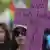 Demonstantin mit einem lila Kreuz in der Hand (Foto: picture-alliance/dpa)