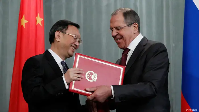 Russian Foreign Minister Sergei Lavrov (R) exchanges documents with his Chinese counterpart Yang Jiechi during a joint news conference in Moscow February 22, 2013. Russia and China regret Pyongyang's recent nuclear test but oppose any foreign military intervention in North Korea, Lavrov said on Friday after talks with Yang. REUTERS/Maxim Shemetov (RUSSIA - Tags: POLITICS)