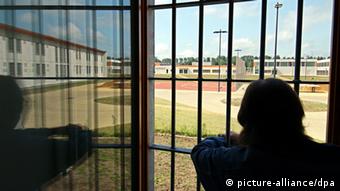 A prisoner looks out from his barred window Photo: Carsten Rehder dpa/lno