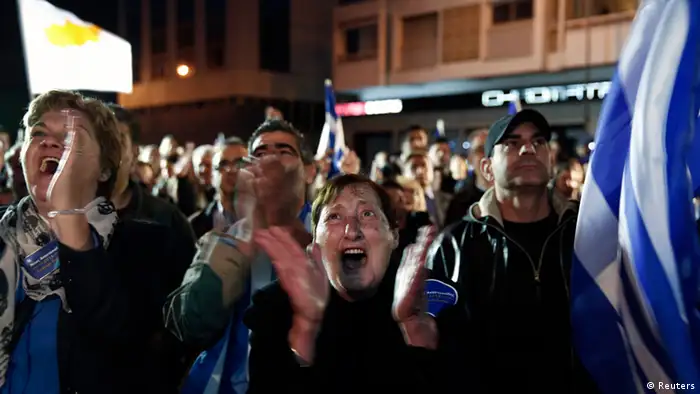Supporters of conservative Cyprus Presidential candidate Nicos Anastasiades celebrate outside a pre-election campaign bureau in Nicosia February 24, 2013. Anastasiades has sealed a convincing victory in Sunday's presidential run-off vote, according to early results, in a boost for investor hopes of a swift financial rescue for the near-bankrupt nation. Anastasiades, who favours hammering out a quick deal with foreign lenders, took 58 percent of the vote after 30 percent of the vote was counted, well ahead of Communist-backed rival Stavros Malas, who has attacked the austerity terms accompanying a rescue. REUTERS/Yorgos Karahalis (CYPRUS - Tags: POLITICS ELECTIONS)