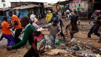 Num bairro de lata de Kibera, em Nairobi, os habitantes apressam-se a recolher camisas oferecidas por um partido