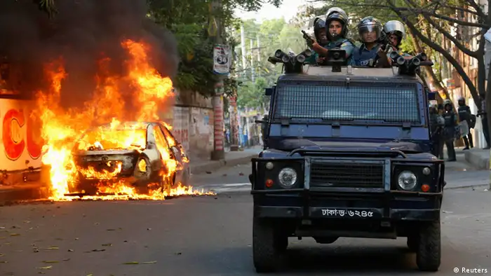 A police van passes a burnt vehicle after activists of Bangladesh Nationalist Party (BNP) set fire to it during a clash in Dhaka March 2, 2013. Activists and supporters of the main opposition BNP torch and vandalise vehicles as they clash with police after a rally organised by BNP and its ally Bangladesh Jamaat-e-Islami called for a three-day country wide shutdown from Sunday, local media reported. REUTERS/Andrew Biraj (BANGLADESH - Tags: POLITICS CIVIL UNREST TPX IMAGES OF THE DAY)