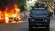Ein Polizeiwagen fährt an einem brennenden Auto in Dhaka vorbei. (Foto: Reuters) Ein Polizeiwagen fährt an einem brennenden Auto in Dhaka vorbei. (Foto: Reuters)