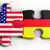 Zwei Puzzleteile sind inenander verhakt. Das eine hat die Farben der USA-Flagge, das andere die Farben der Deutschland-Flagge. Copyright: zentilia - Fotolia.com