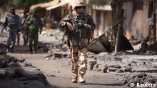 A French soldier walks through the destroyed main market in Gao, March 2, 2013. French soldiers visited the market on Saturday, nine days after it was destroyed during fighting between radical Islamists and Malian and French soldiers. REUTERS/Joe Penney (MALI - Tags: CIVIL UNREST CONFLICT MILITARY POLITICS TPX IMAGES OF THE DAY)
