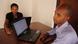Software developers in Rwanda, sitting at a table with a laptop Software developers in Rwanda, sitting at a table with a laptop