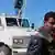 Сирийский повстанец перед захваченным автомобилем ООН