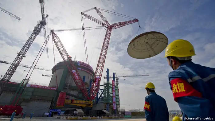Workers watch contruction at Changjiang Nuclear Power Plant in Tangxing