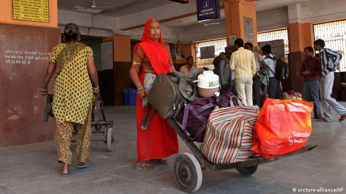 Eine indische Frau transportiert Gepäck von Bahnreisenden (Foto: ap)