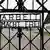 Дверь с надписью Arbeit macht frei на воротах в мемориал в Дахау