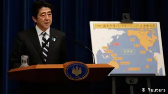Japan's Prime Minister Shinzo Abe speaks next to a map showing participating countries in rule-making negotiations for the Trans-Pacific Partnership (TPP) during a news conference at his official residence in Tokyo March 15, 2013. Abe announced on Friday that Tokyo will seek to join talks on a U.S.-led Pacific free trade pact which proponents say will tap vibrant regional growth, open Japan to tough competition and boost momentum for reforms needed to revive the long-stagnant economy. REUTERS/Toru Hanai (JAPAN - Tags: BUSINESS POLITICS)