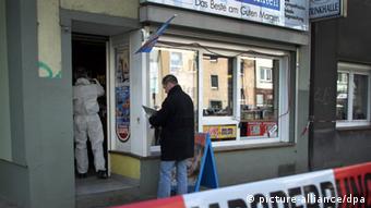 Polizeibeamte untersuchen nach dem Mord den Kiosk auf Spuren (Foto: dpa)