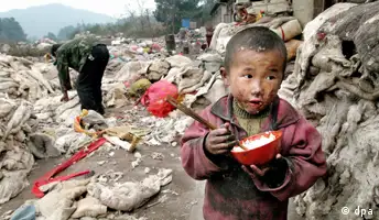 Ein vierjähriger Junge isst Reis aus einer Schale, während sein Vater auf der Müllhalde in Guiyang (Provinz Guizhou) nach Verwertbarem sucht (Archivfoto vom 28.12.2003). Nicht nur in Entwicklungsländern werden Kinder aufgrund der vorhandenen Armut vielfach nicht ausreichend ernährt und medizinisch versorgt. Der Zusammenhang zwischen sozialer Benachteiligung und negativen Auswirkungen auf die Gesundheit bereits bei Kindern und Jugendlichen ist auch in Deutschland unbestritten, sagt die Direktorin der Bundeszentrale für gesundheitliche Aufklürung (BZgA). Foto: Woo Jun (Zu dpa KORR: Arme Kinder oft auch kranke Kinder - Nicht nur in der Dritten Welt vom 01.04.2005) +++(c) dpa - Bildfunk+++