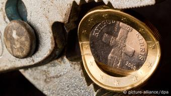 A Cyprus EU coin being squeezed by a pair of pliers
Copyright: Patrick Pleul/dpa
