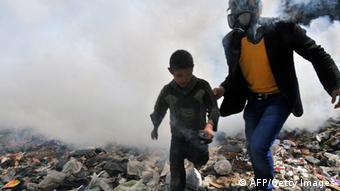 Ein Mann mit einer Gasmaske und ein Junge (Foto: /BULENT KILIC/AFP)