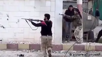 In this image taken from video obtained from the Shaam News Network, which has been authenticated based on its contents and other AP reporting, Free Syrian Army fighters fire at Syrian army soldiers during a fierce firefight in Daraa al-Balad, Syria, Monday March 18, 2013. Two years after the anti-Assad uprising began, the conflict has become a civil war, with hundreds of rebel group fighting Assad's forces across Syria and millions of people pushed from their homes by the violence. The U.N. says more than 70,000 people have been killed. (AP Photo/Shaam News Network via AP video)