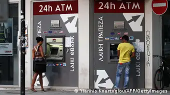 People withdraw money from an Automated Teller Machine (ATM) of Laiki (Popular) bank in the Cypriot capital Nicosia on June 25, 2012. Cyprus's central bank said it backed the government's move to request a bailout from the EU as it would protect its Greek-exposed banking sector from further contagion. AFP PHOTO/YIANNIS KOURTOGLOU (Photo credit should read Yiannis Kourtoglou/AFP/GettyImages)